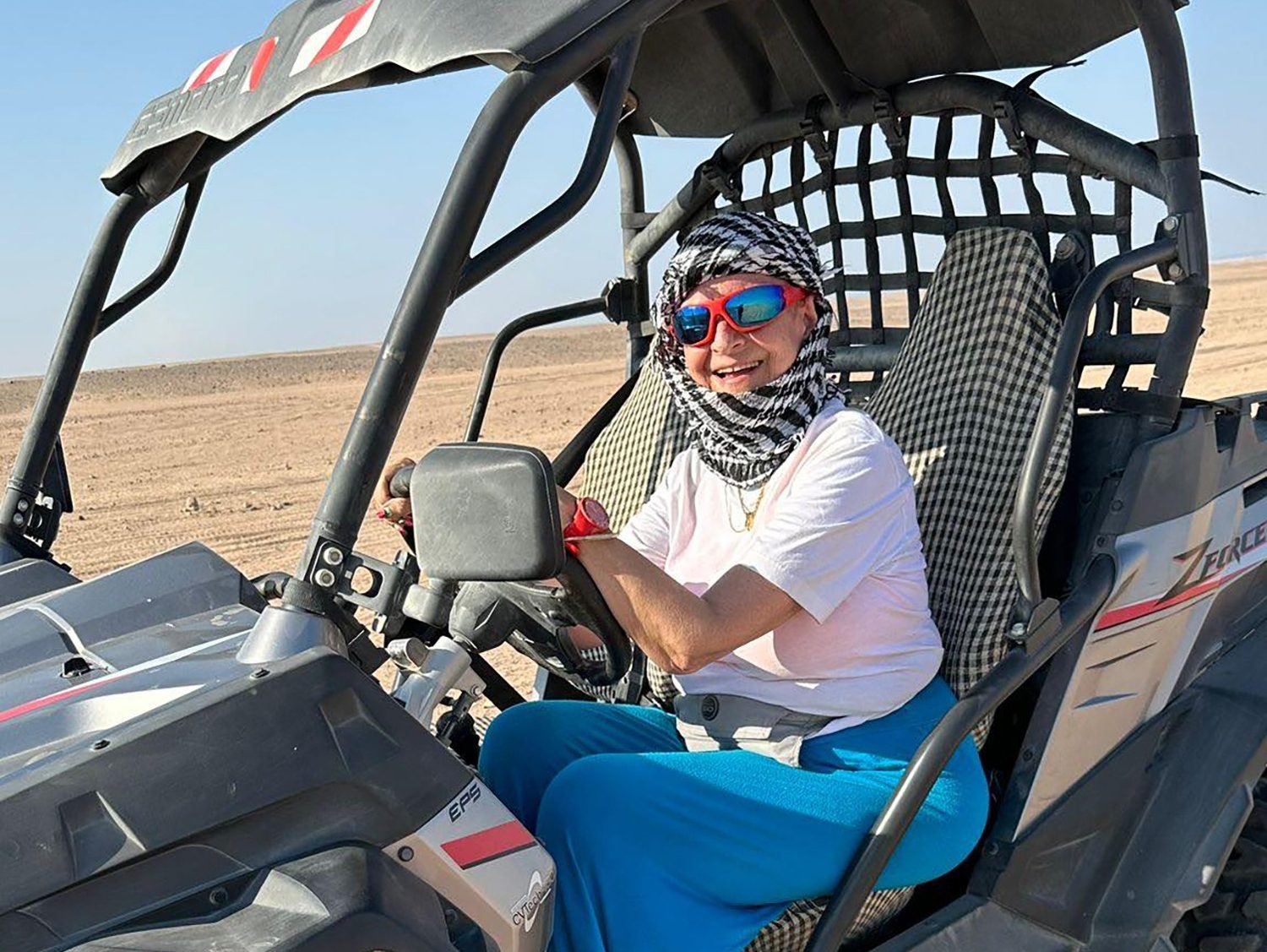 Family posing together on quads and spidercar in the desert