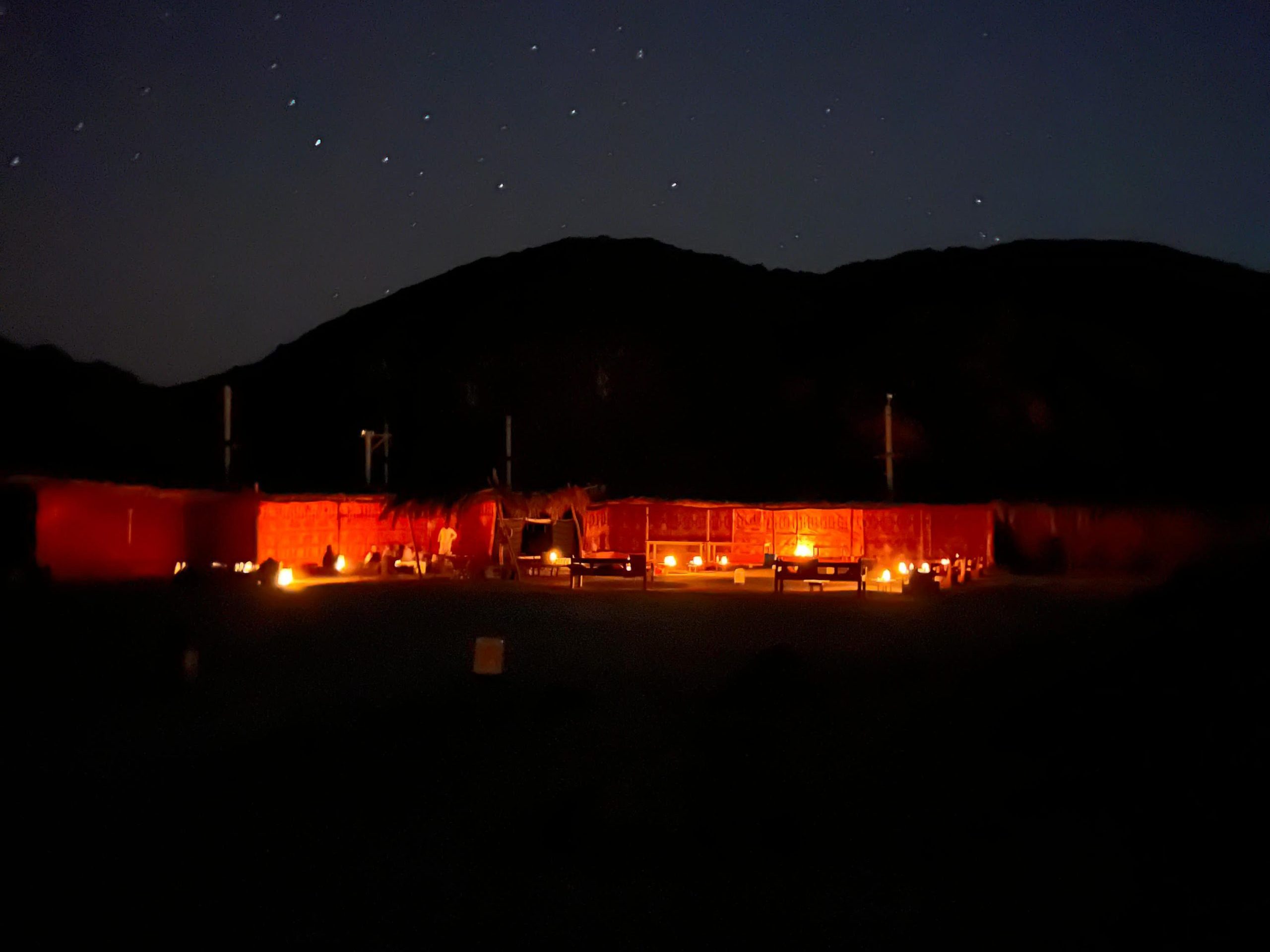 Bedouin tent set up for stargazing evening with lamps and cushions
